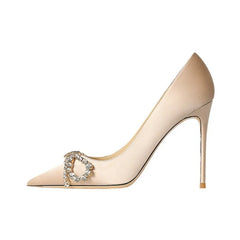 Beige high-heeled shoe with a decorative buckle on a white background