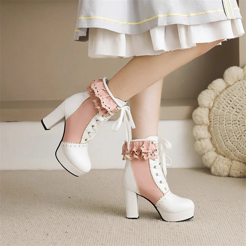 White platform high heels with lace details worn by a person in a light-colored outfit.