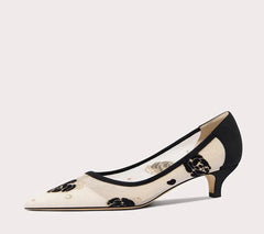 Black and white high-heeled shoe with floral design on a light gray background