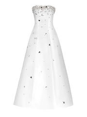 White strapless evening gown with black heart patterns and silver embellishments on a white background