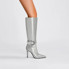 Silver glitter knee-high boot with a buckle on a light gray background