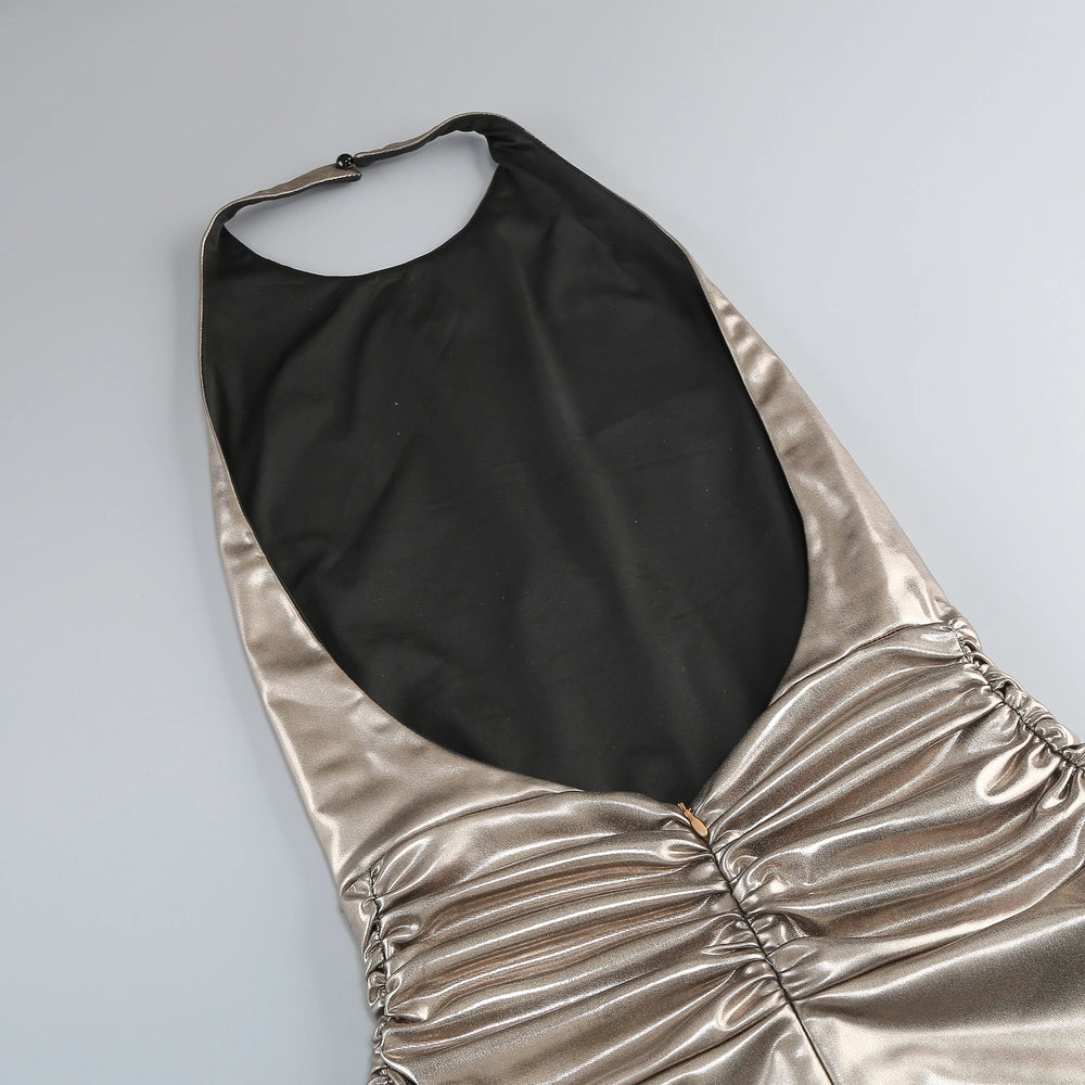Gold halter dress with black lining on a light gray background