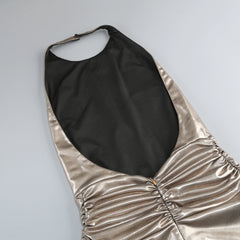 Gold halter dress with black lining on a light gray background