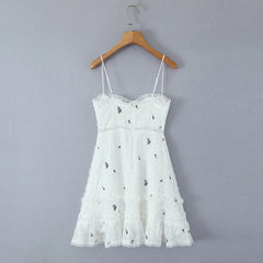 White lace dress on a wooden hanger against a gray background