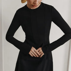 Person wearing a black long-sleeve dress
