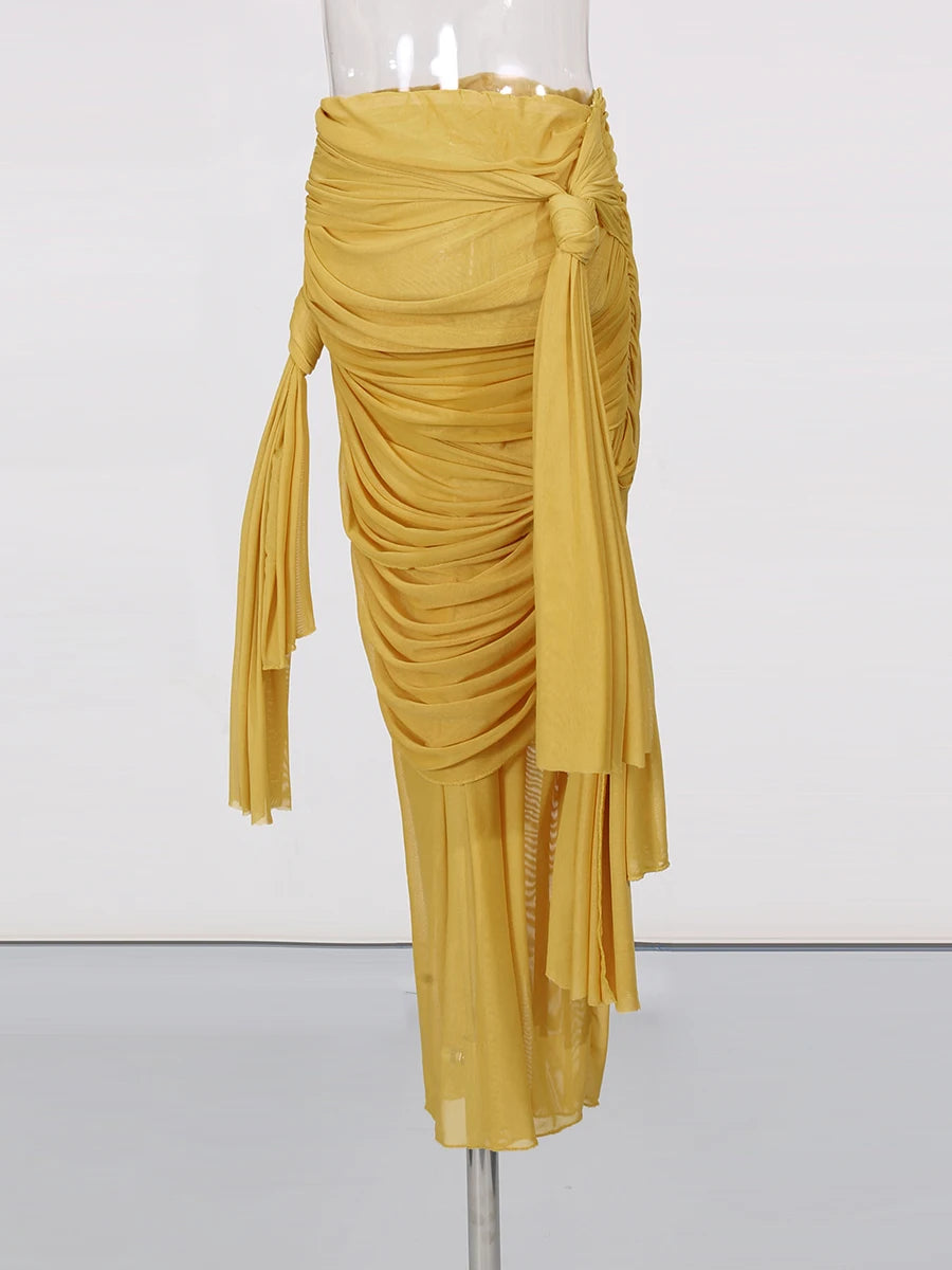 Mustard yellow draped skirt on a mannequin against a white background