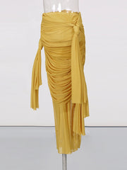 Mustard yellow draped skirt on a mannequin against a white background