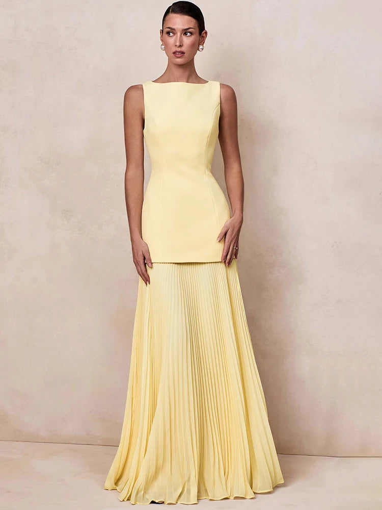 Boat neck sleeveless dress with a floor-length pleated skirt in yellow.
