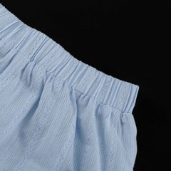 Light blue fabric with lace detailing on a black background