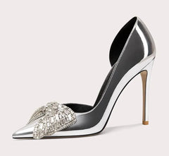 Silver high-heeled shoe with decorative element on a light gray background