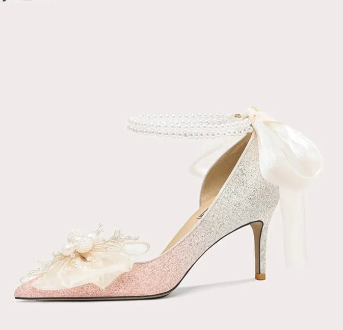 High-heeled shoe with decorative bow on a white background