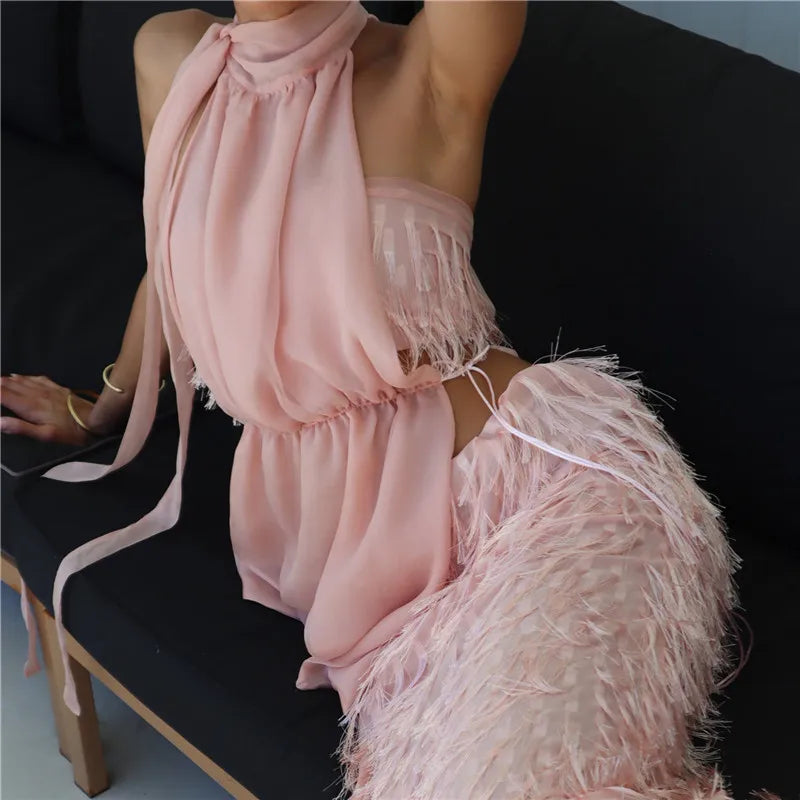 Person wearing a pink fringe dress sitting on a black chair.
