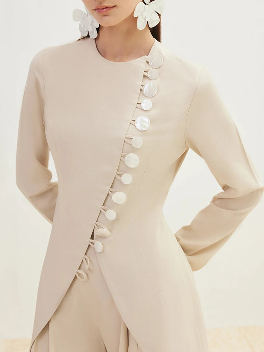 Beige outfit with floral details on a plain background