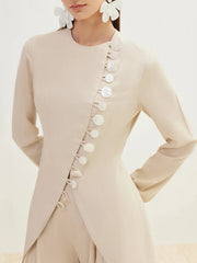 Beige outfit with floral details on a plain background