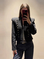 Woman wearing a black cropped military style jacket with gold buttons and cord braiding