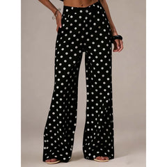 Black polka dot pants worn by a person on a neutral background