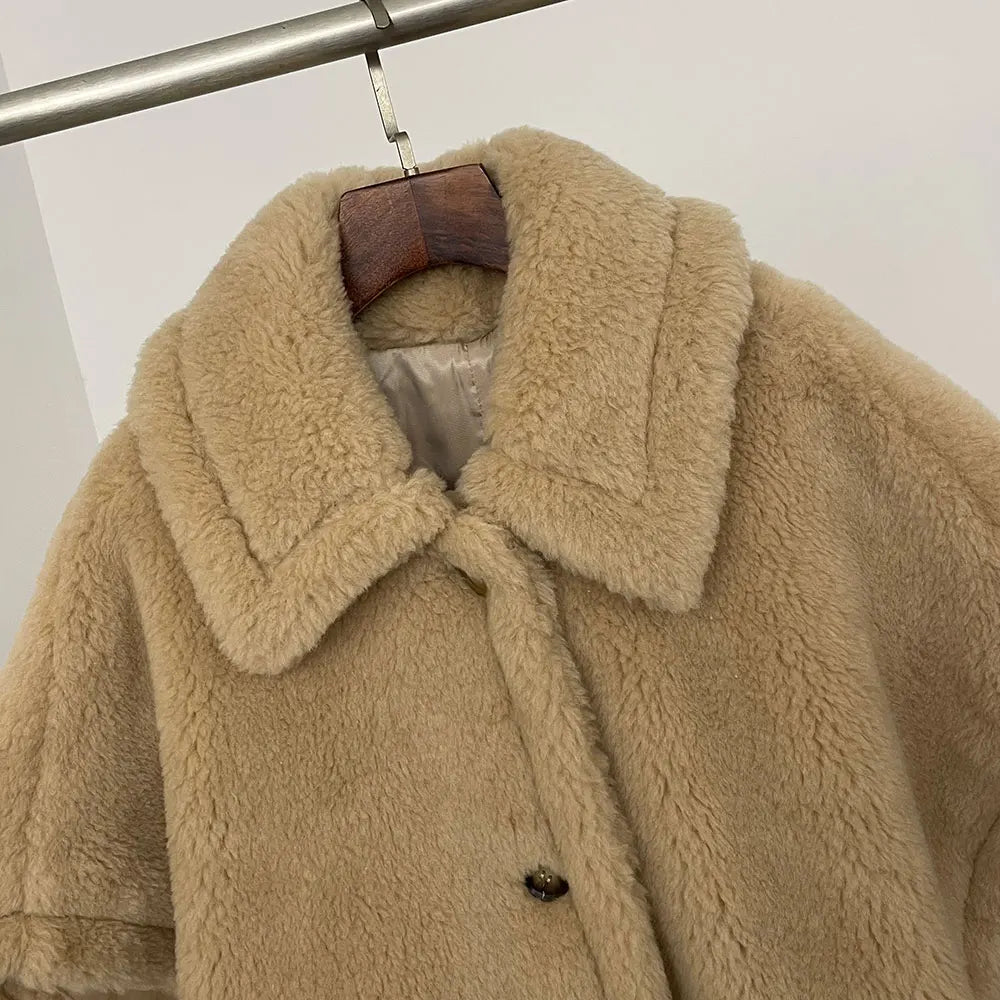 Beige fluffy coat on a hanger against a white background