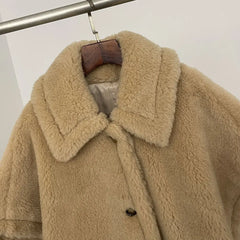 Beige fluffy coat on a hanger against a white background