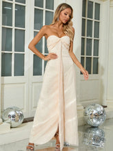 Woman in a strapless white gown standing in a room with disco balls.