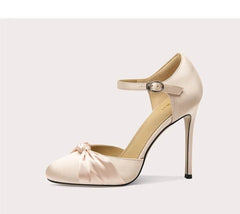 High-heeled shoe with bow detail on a white background