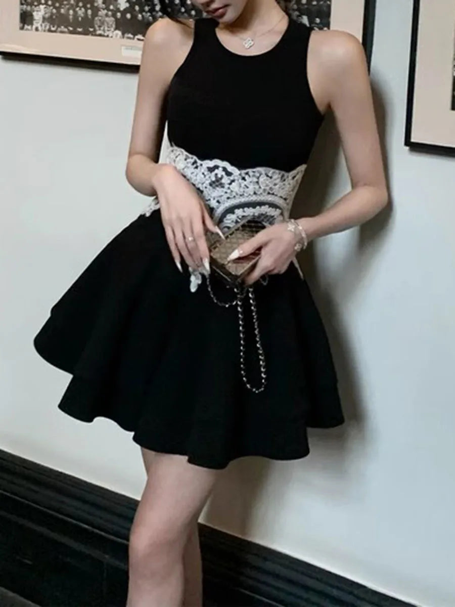 Woman wearing a black dress with white lace details, holding a clutch.