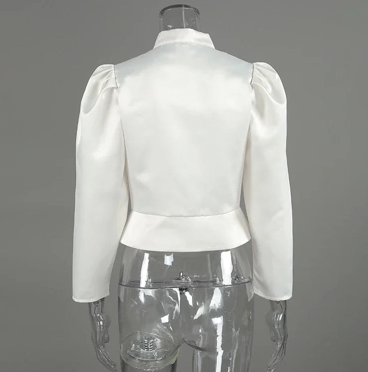 White blouse with puffed sleeves on a mannequin against a gray background