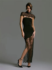 Woman wearing a black dress with sheer lace details on a gray background