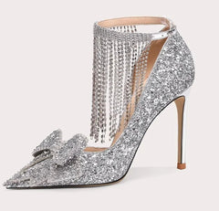 Silver high-heeled shoe with decorative elements on a white background