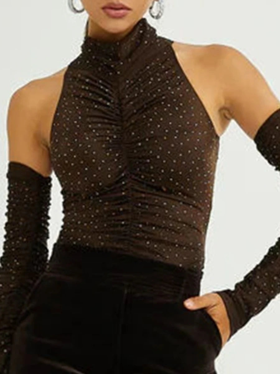 Person wearing a brown sequin top and black pants with long gloves on a light gray background