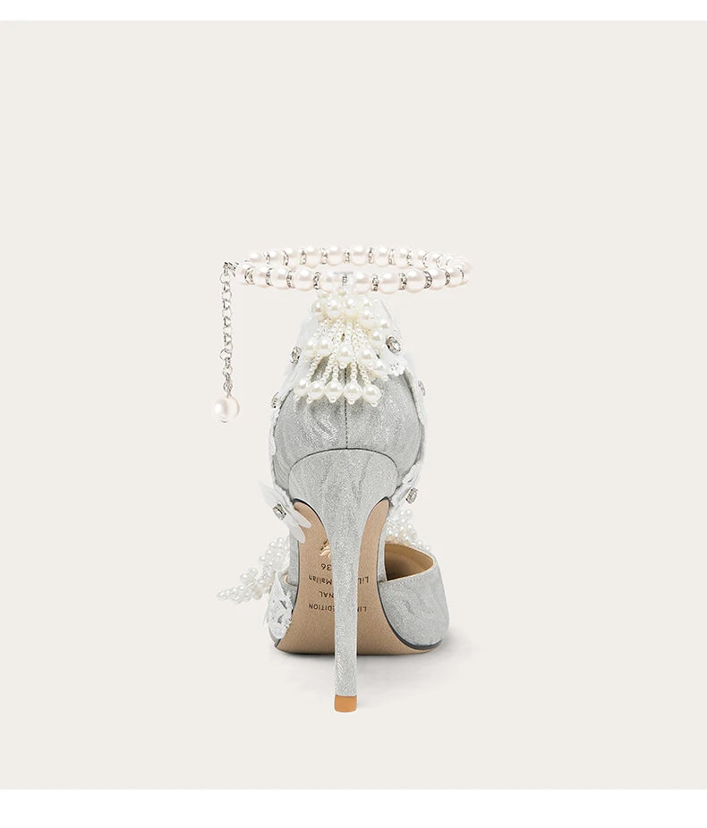 Silver high-heeled shoe with decorative elements on a white background