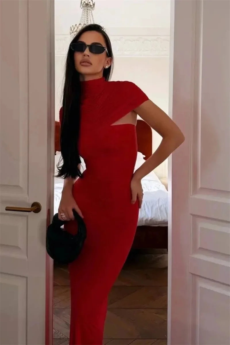 Woman in a red dress standing in a doorway.