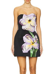 Woman wearing a strapless dress with floral design on a white background