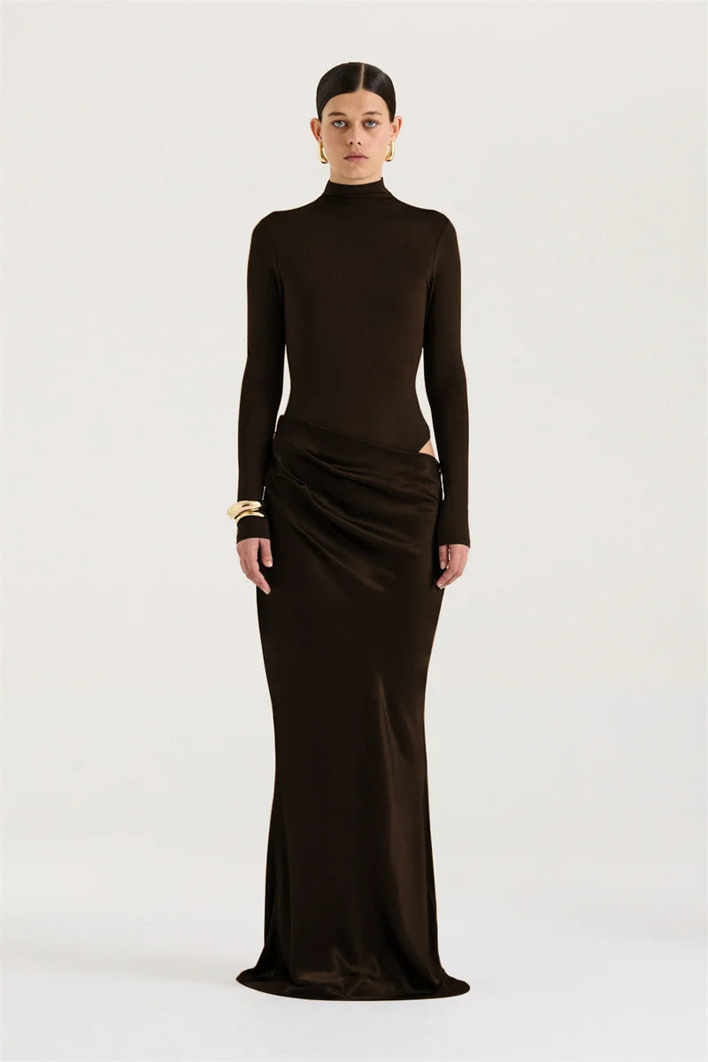 Woman wearing a long black dress with a high neckline on a white background