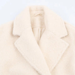 Close-up of a cream-colored coat on a light gray background