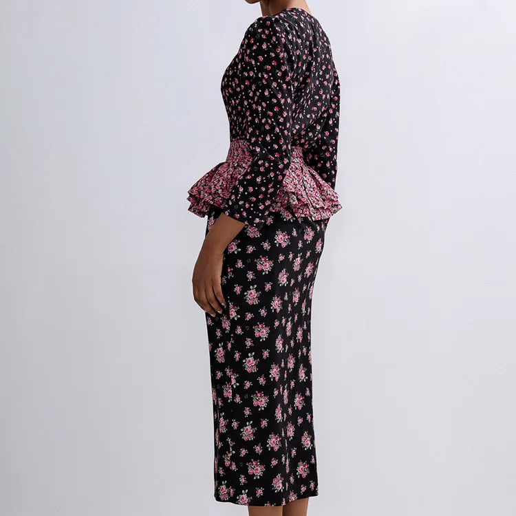 Woman wearing a black floral dress with ruffled sleeves on a white background