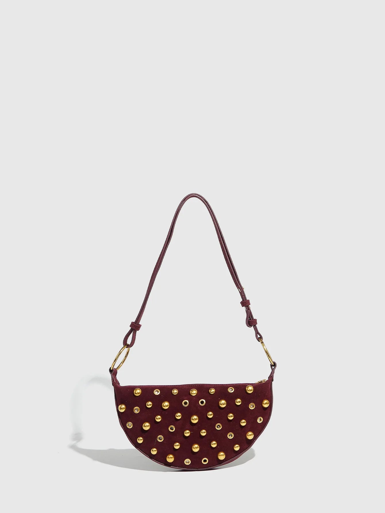Maroon handbag with gold studs on a light gray background