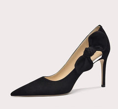 Black high-heeled shoe with a bow on a light gray background