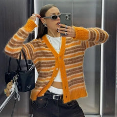 Woman taking a mirror selfie wearing an orange and brown striped cardigan.