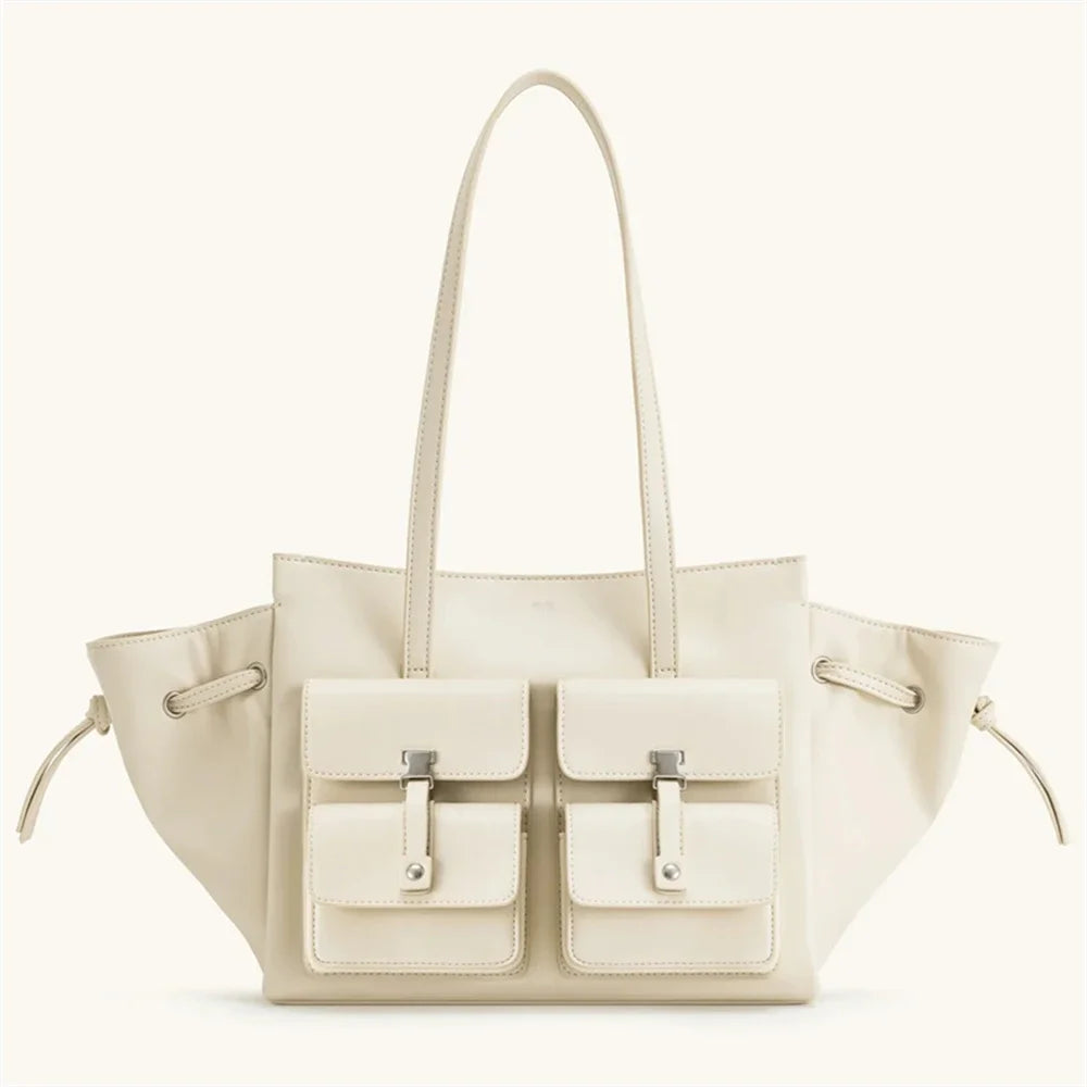 Beige handbag with two front pockets on a white background