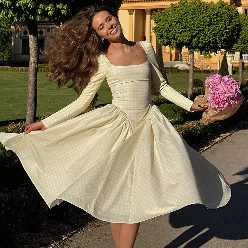 Woman in a white dress holding pink flowers outdoors
