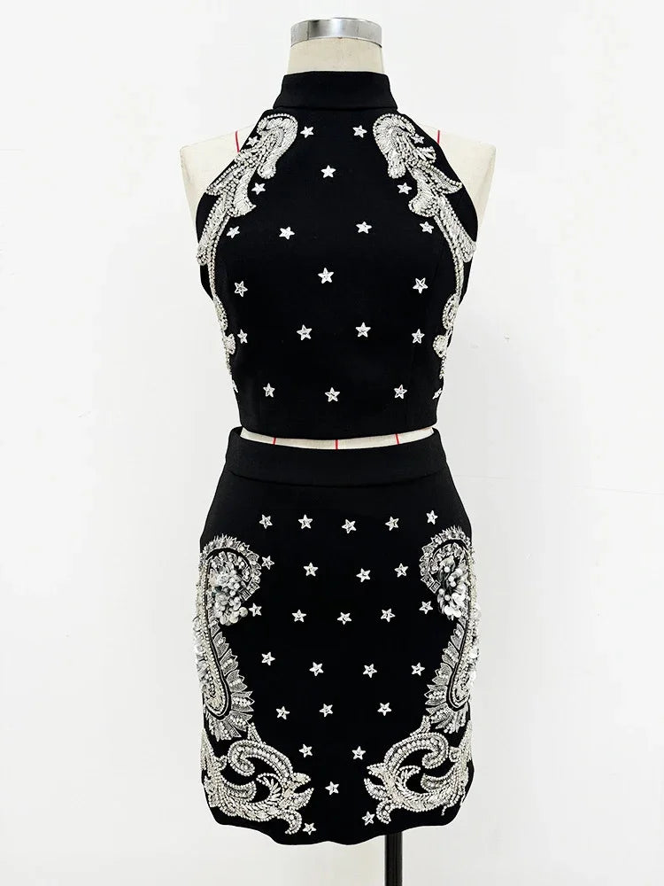 Black dress with white embroidery on a mannequin against a white background