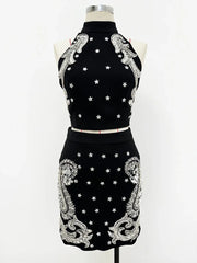 Black dress with white embroidery on a mannequin against a white background