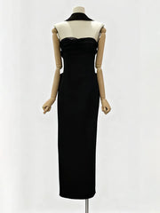 Black evening gown on a mannequin against a white background