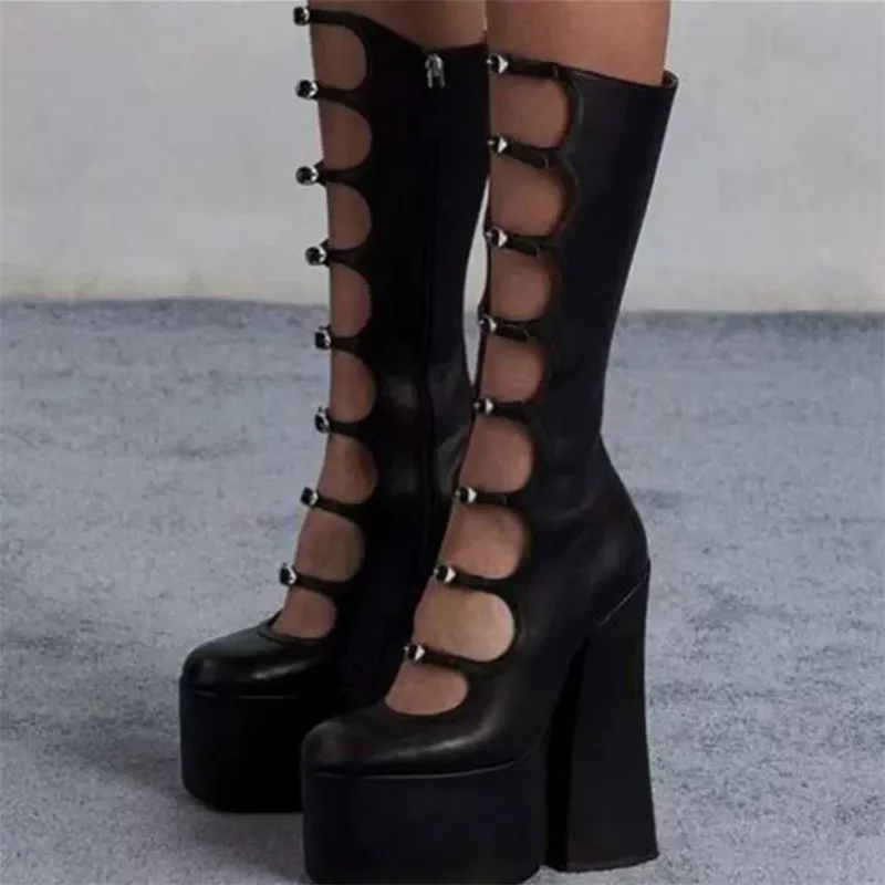 Black platform boots with cut-out design on a gray background