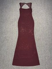 Maroon evening gown with cut-out back on a gray surface