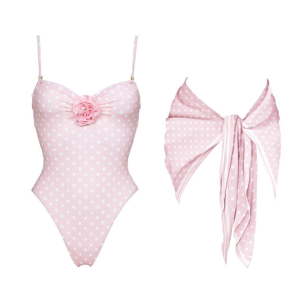 Pink polka dot one-piece swimsuit with floral accent and matching scarf.