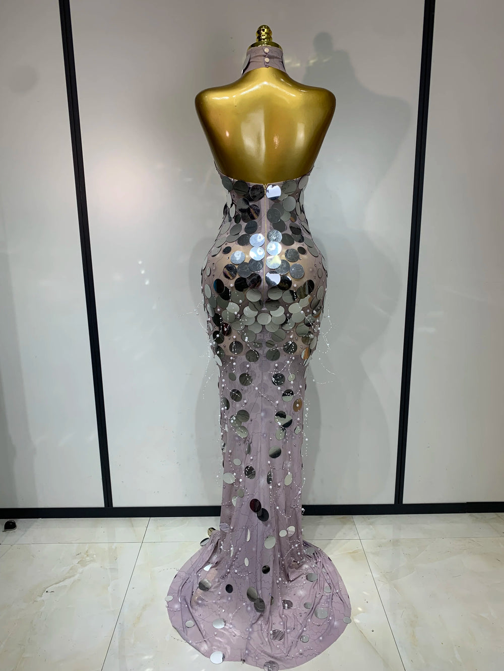 Silver sequin evening gown on a mannequin against a neutral background
