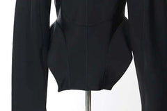 Black long-sleeve top on a mannequin against a white background