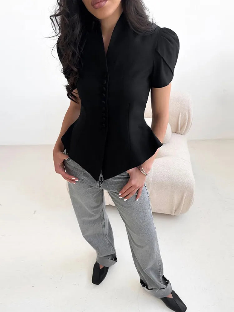 Person wearing a black blouse and gray pants on a white background