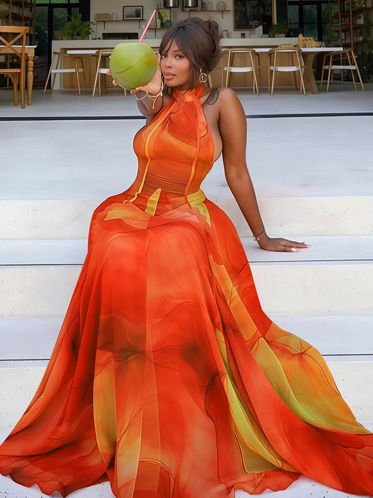 Woman sitting on steps wearing an abstract print halter neck maxi dress